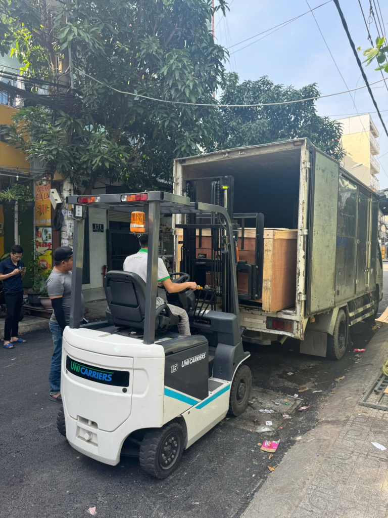 Xe n&acirc;ng đưa kiện gỗ v&agrave;o th&ugrave;ng xe tải tại điểm giao nhận