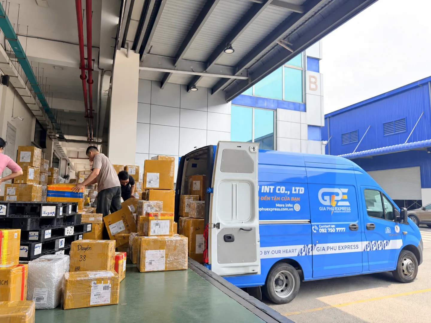 Gia Phu Express staff preparing cargo beside a transport vehicle at the warehouse